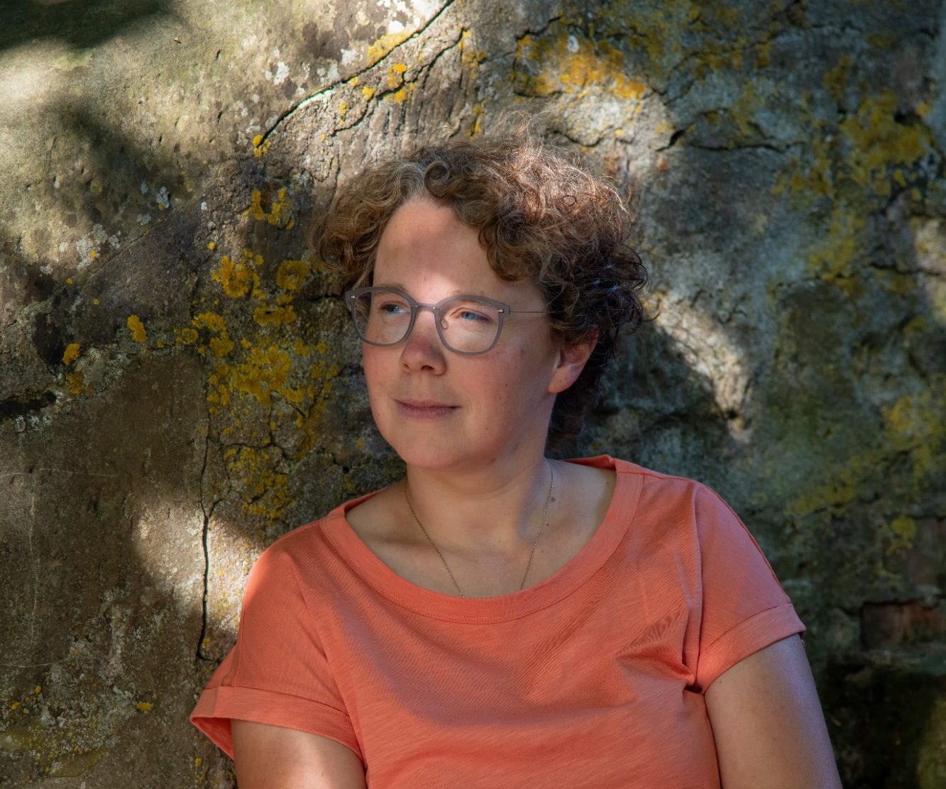 Anja Graf - Freie Rednerin aus Schwäbisch Hall Profil einer lächelnden Frau mit kurz geschnittenen Locken vor einer historischen Häuserfassade